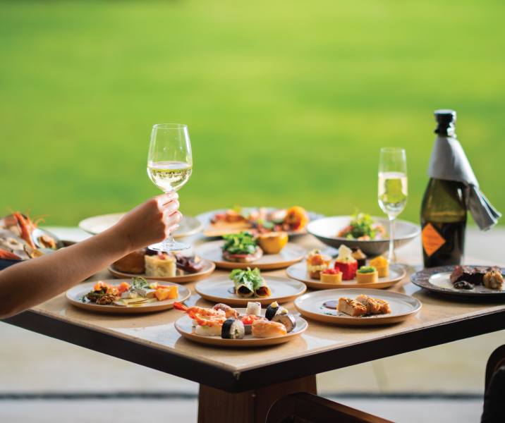 Romantic beachfront dinner setup with candlelight and sea breeze, capturing experiences at the best beach resorts in Sanur Bali.