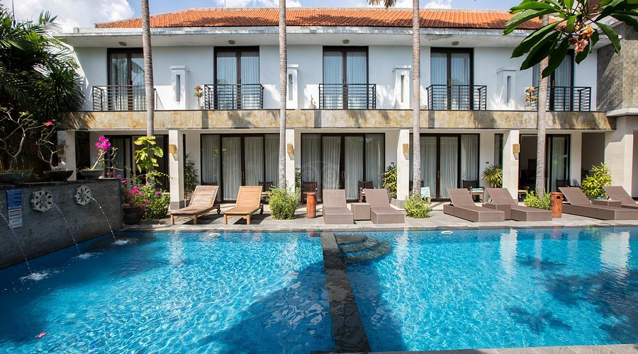 Tropical beachfront property lined with palm trees and sunrise views, highlighting the best beach resorts in Sanur Bali.