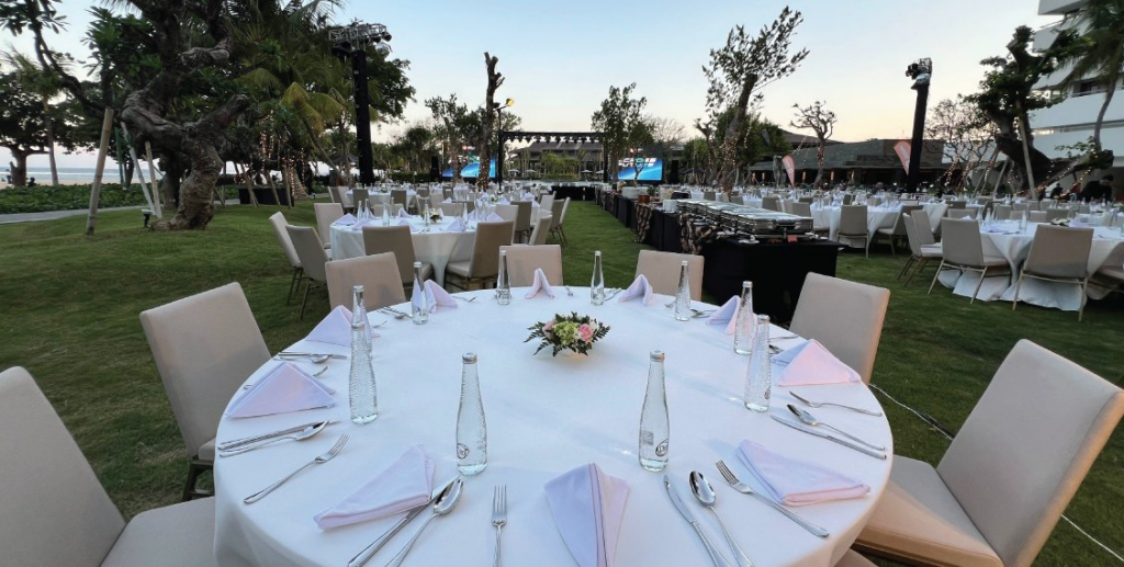 Wedding guests enjoying an oceanfront dinner setup at a five-star resort, representing sophisticated luxury weddings Sanur Bali.