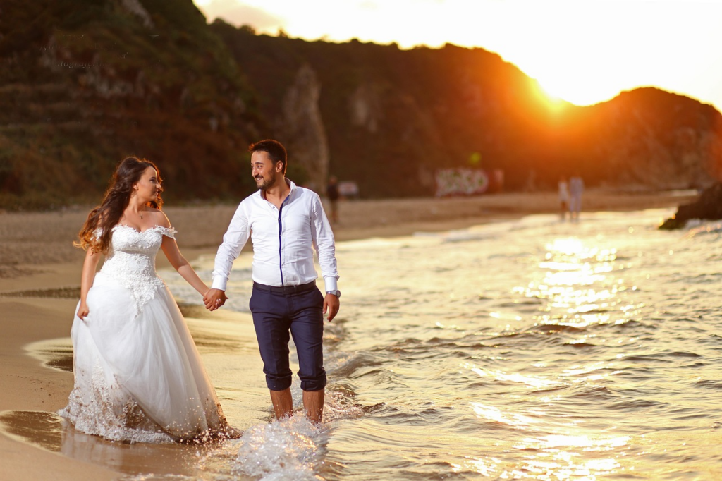Couple posing at sunset with the calm Sanur shoreline behind, reflecting the romance of luxury weddings Sanur Bali.
