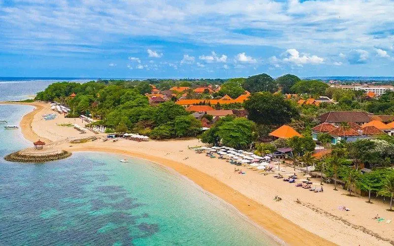 Beachfront view at one of the best family resorts in Sanur Bali with kids enjoying the pool