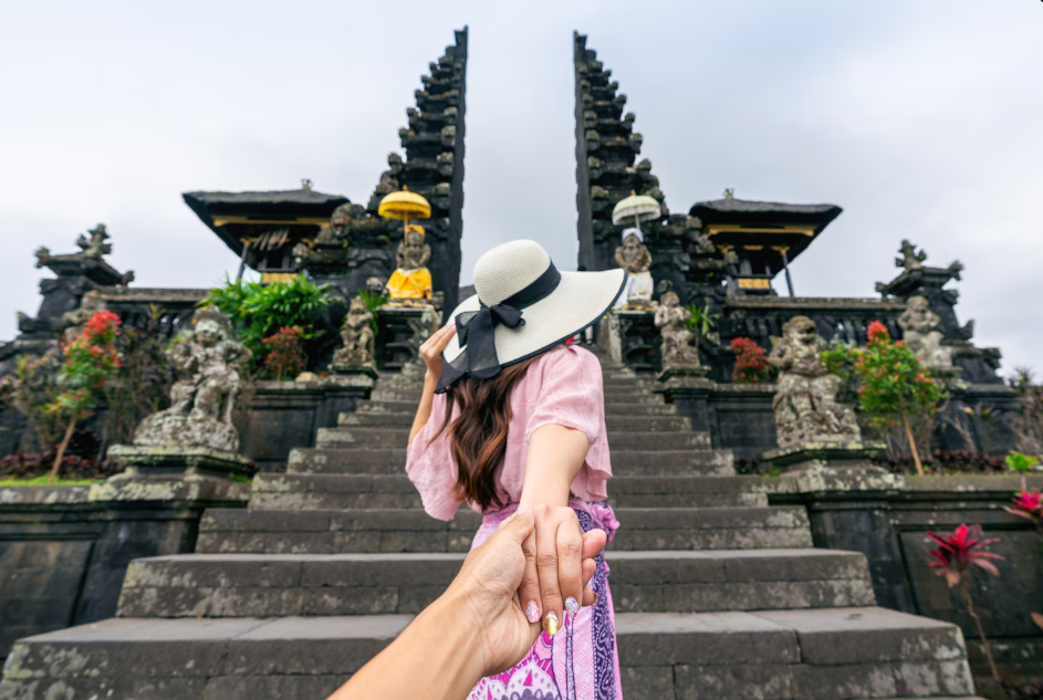 Visitors exploring Besakih Temple in Bali, walking through the sacred temple complex surrounded by lush greenery.