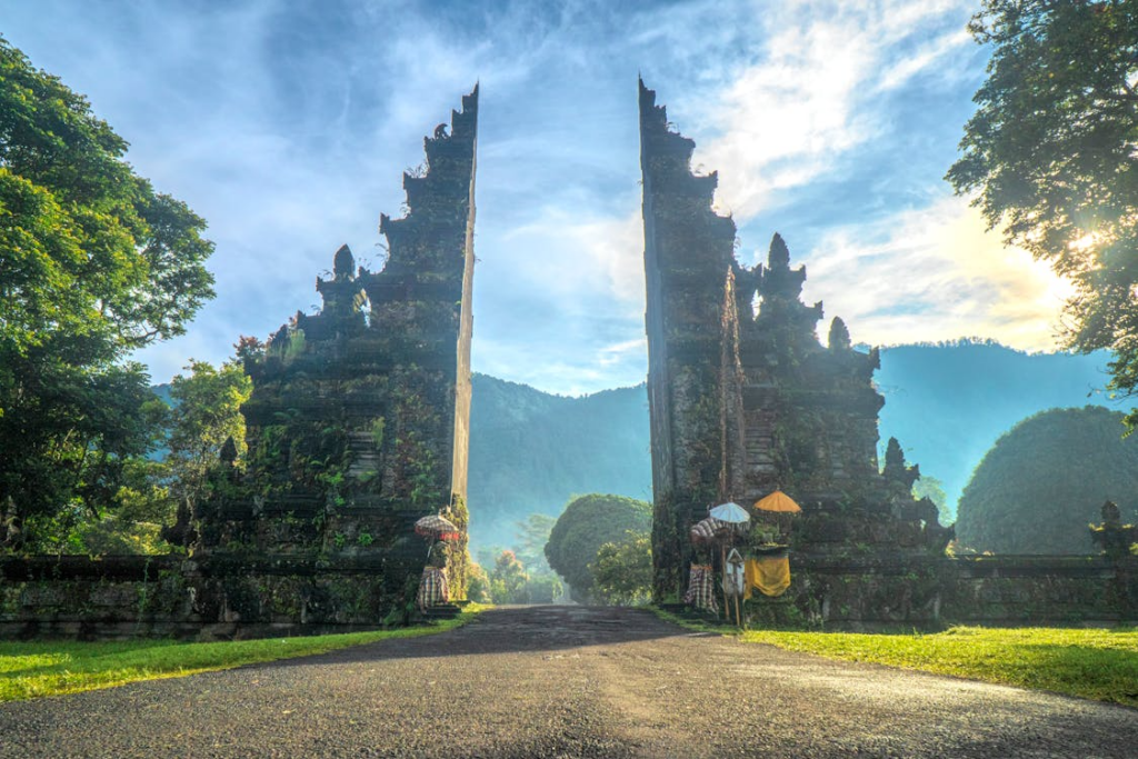 Visitors exploring Besakih Temple in Bali, walking through the sacred temple complex surrounded by lush greenery.