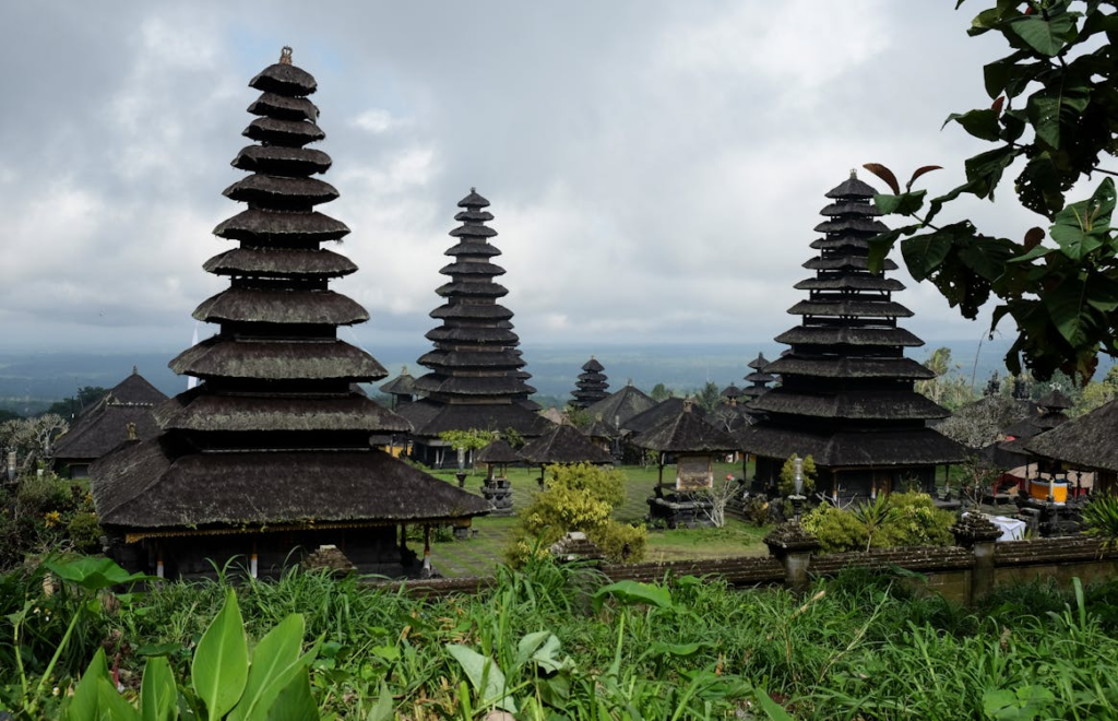 Visitors exploring Besakih Temple in Bali, walking through the sacred temple complex surrounded by lush greenery.